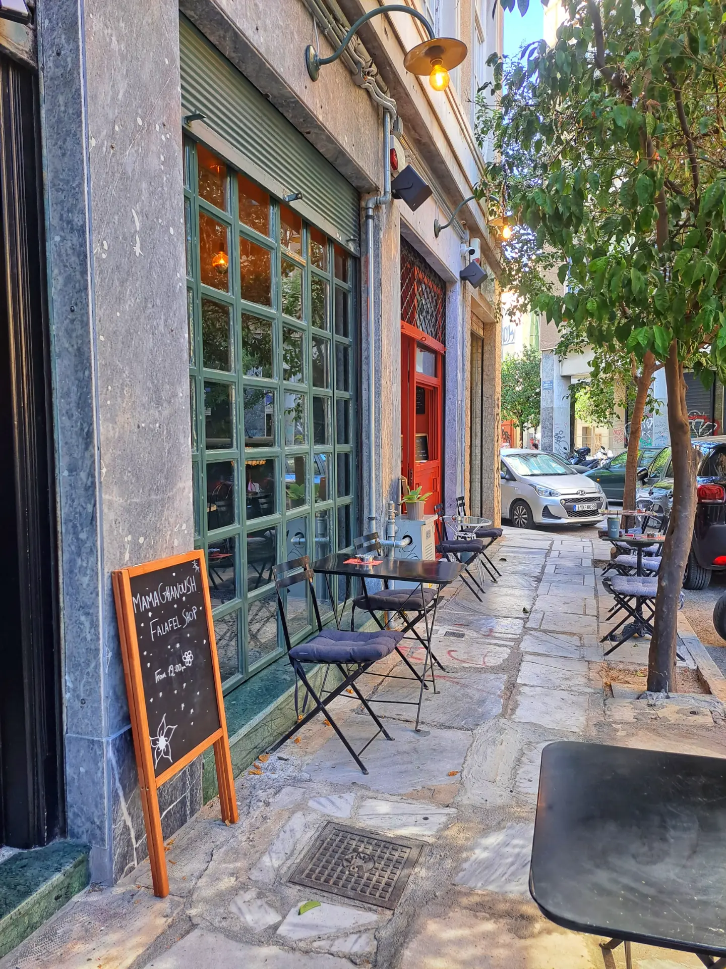 The street outside the coffee shop with chairs and a chalkboard